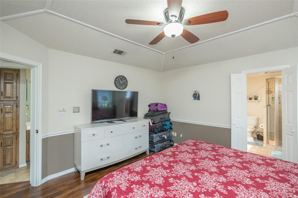 116 Meadowglen Circle Coppell, TX 75019 - Photo 20 of 32 a bedroom with a bed and a flat screen tv on a dresser