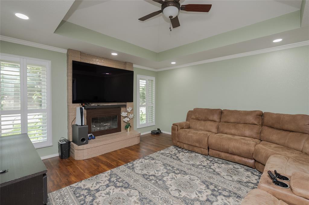 116 Meadowglen Circle Coppell, TX 75019 - Photo 3 of 32 a living room with furniture a flat screen tv and a fireplace