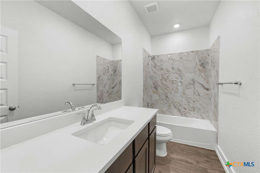 8917 Ponderosa Pine Road Temple, TX 76502 - Photo 11 of 16 a bathroom with a granite countertop sink a toilet and shower