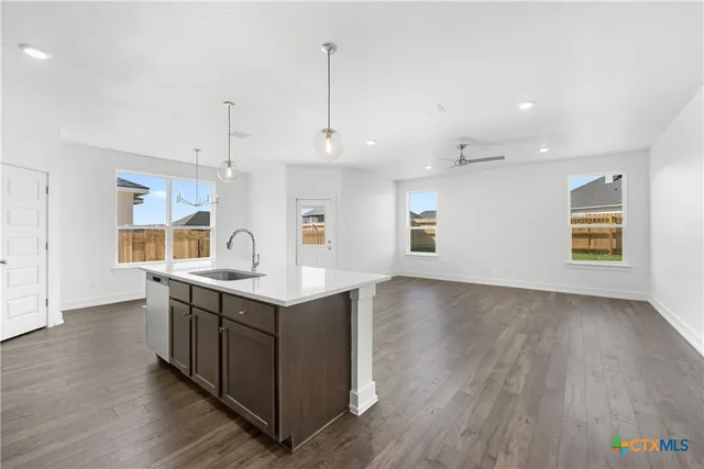 a kitchen with a sink cabinets and wooden floor