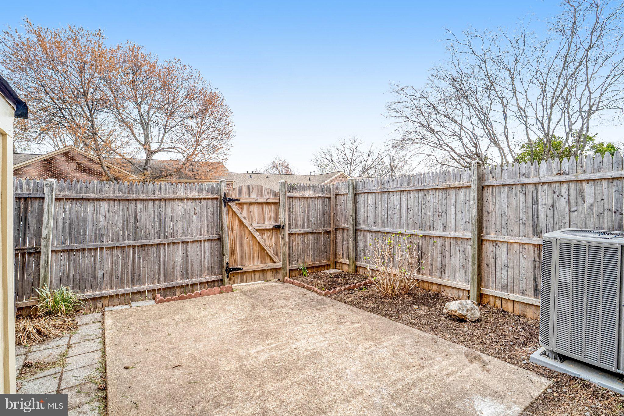 8396 Forrester Boulevard, Unit 555 Springfield, VA 22152 - Photo 23 of 24 a view of a backyard with wooden fence and large trees