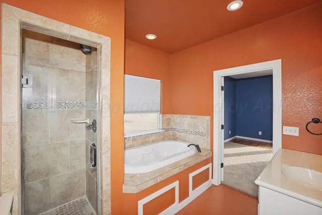 a bathroom with a granite countertop sink a mirror and shower