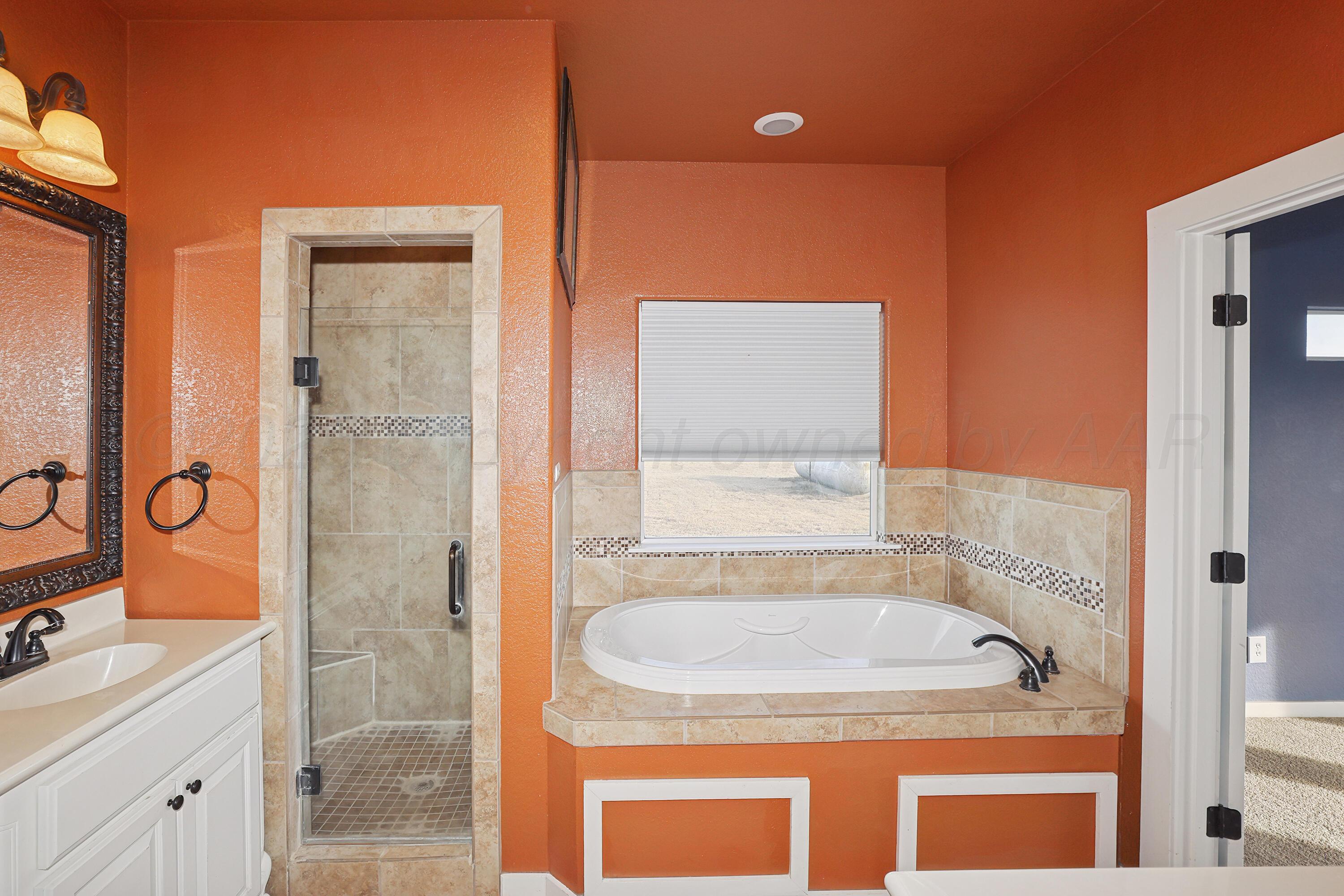 5282 County Road 8 Claude, TX 79019 - Photo 18 of 51 a bathroom with a granite countertop sink a mirror and shower