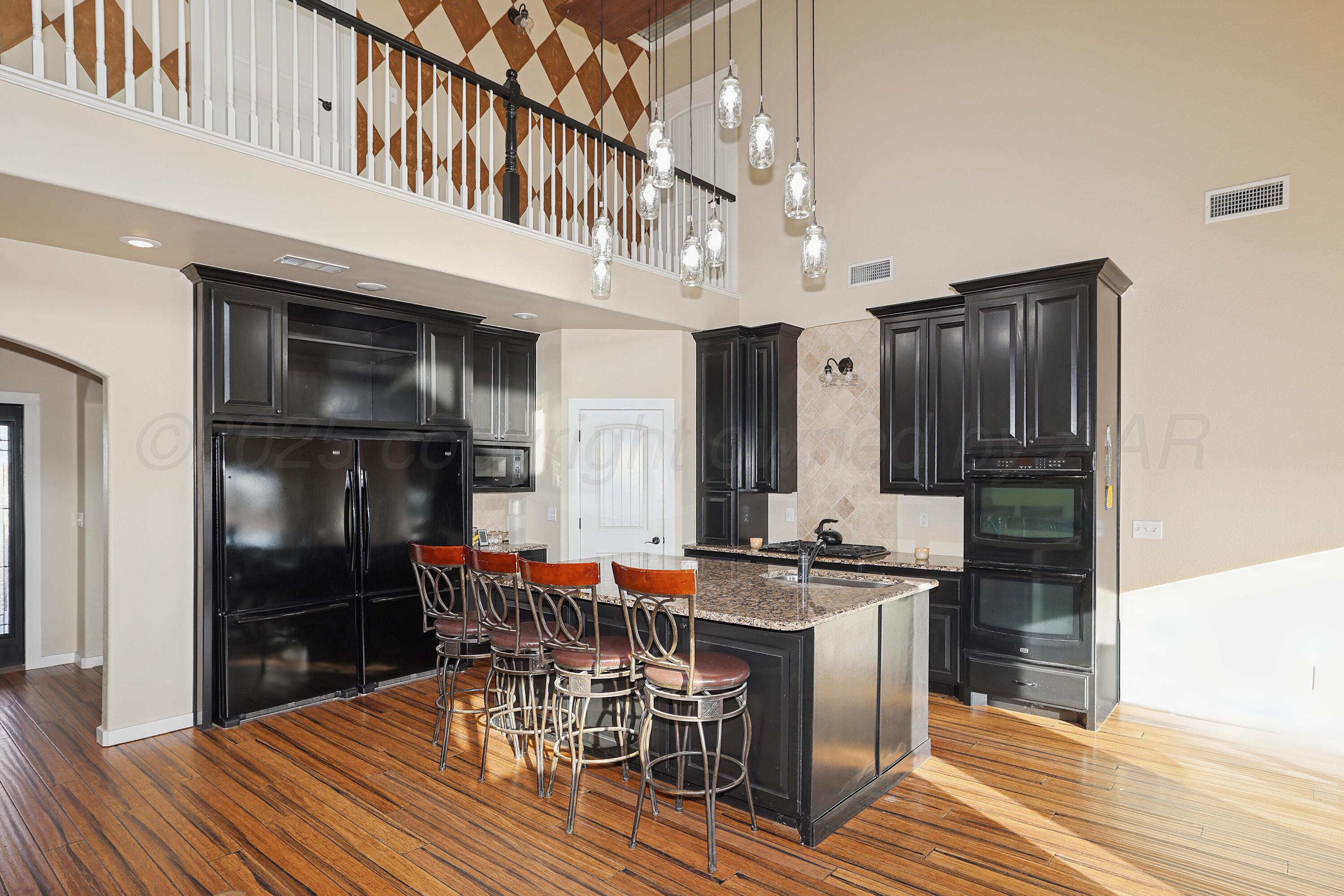 5282 County Road 8 Claude, TX 79019 - Photo 10 of 51 a kitchen with stainless steel appliances kitchen island granite countertop a refrigerator and a stove top oven