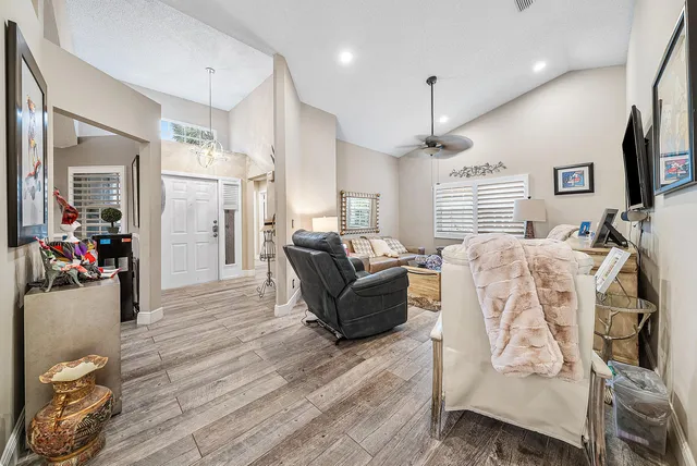 a living room with furniture a flat screen tv and kitchen view
