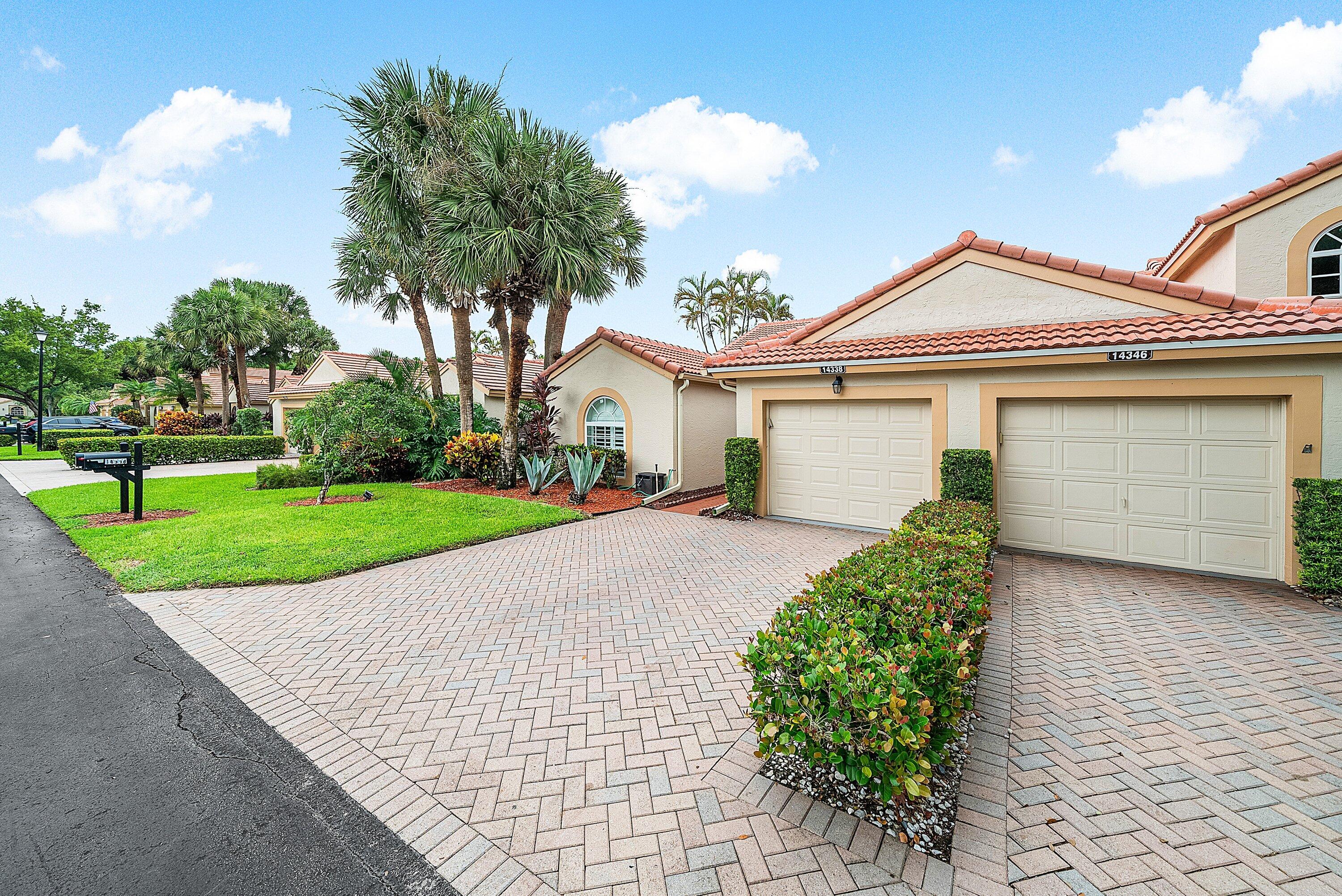 14338 Ruby Pointe Drive Delray Beach, FL 33446 - Photo 2 of 36 a front view of a house with a yard and potted plants