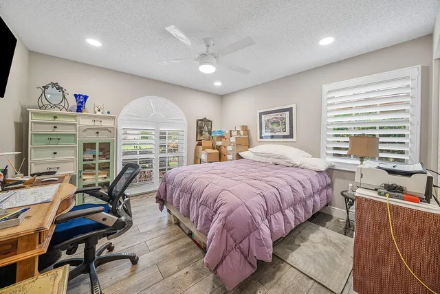 a spacious bedroom with a bed a table and chair