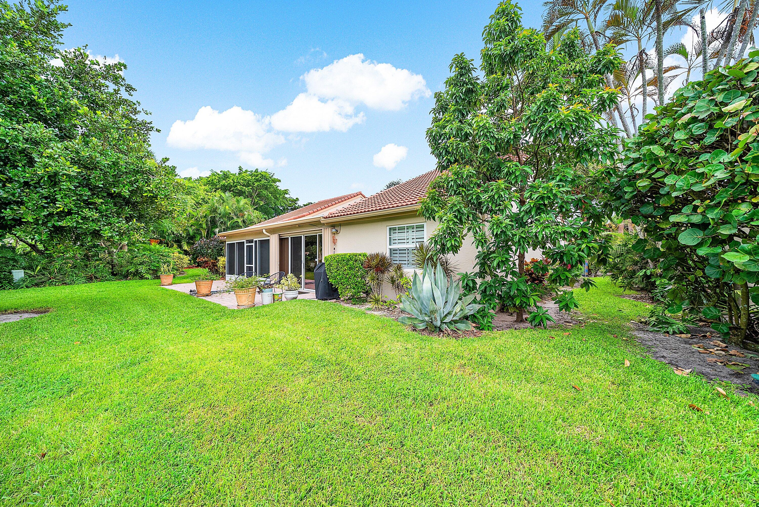 14338 Ruby Pointe Drive Delray Beach, FL 33446 - Photo 31 of 36 a view of a house with a big yard potted plants and large tree