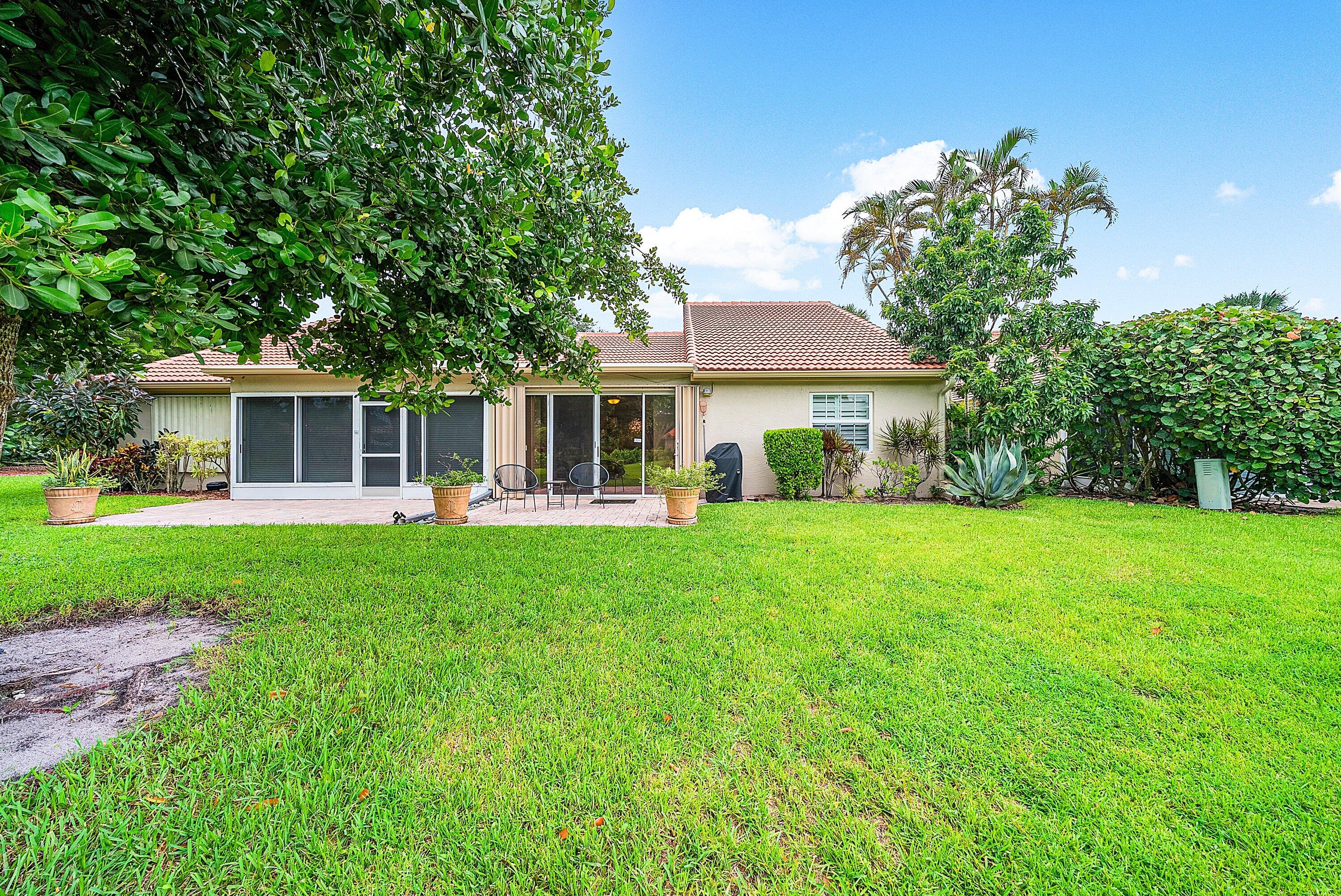 14338 Ruby Pointe Drive Delray Beach, FL 33446 - Photo 32 of 36 a front view of a house with a garden