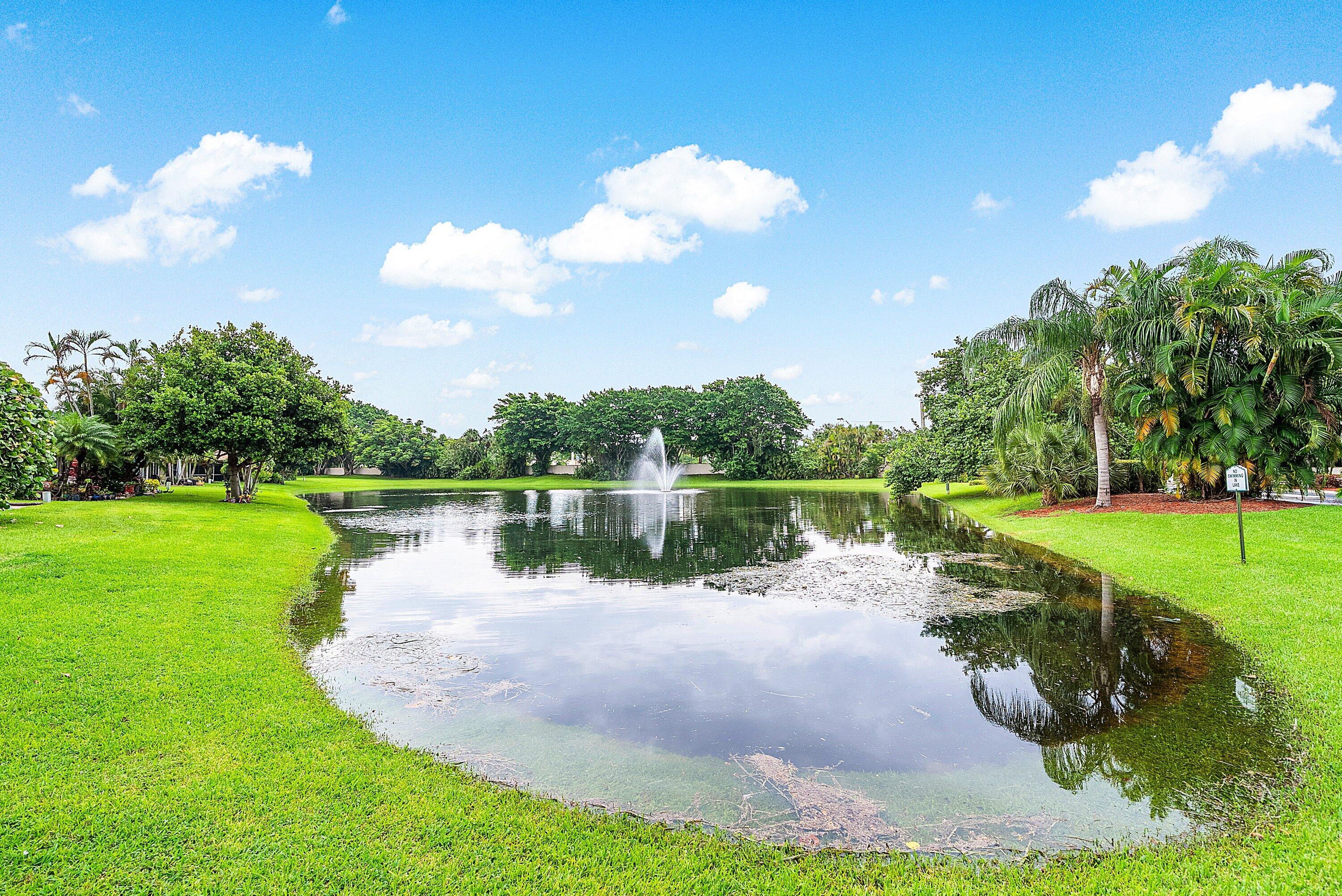 14338 Ruby Pointe Drive Delray Beach, FL 33446 - Photo 35 of 36 a view of a lake with a yard and a large tree