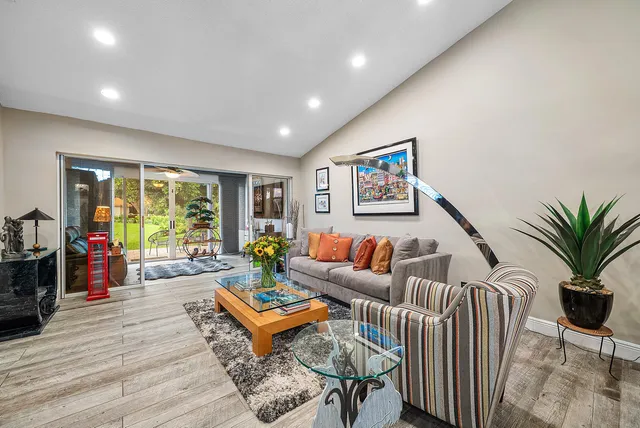 a living room with furniture a large window and a flat screen tv