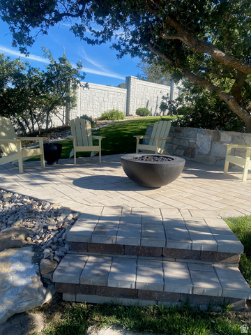 3167 South Mapleton Ests Drive Mapleton, UT 84664 - Photo 37 of 43 Paver patio featuring a built-in fire bowl, stone retaining wall, and two-tier paver steps