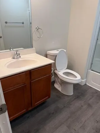 a bathroom with a toilet sink and mirror