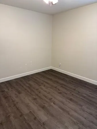 a view of an empty room with wooden floor