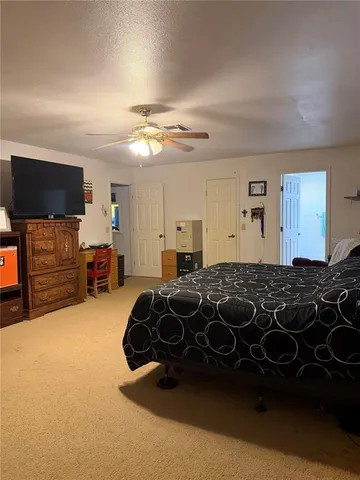 a bedroom with a bed and a flat tv screen on dresser