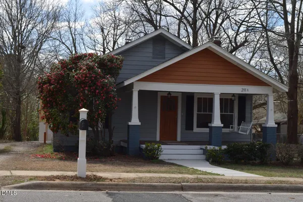 a front view of a house with garage and trees