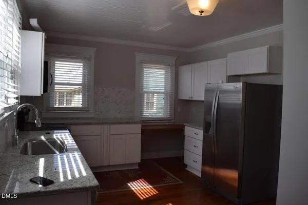 a kitchen with a refrigerator stove and wooden cabinets