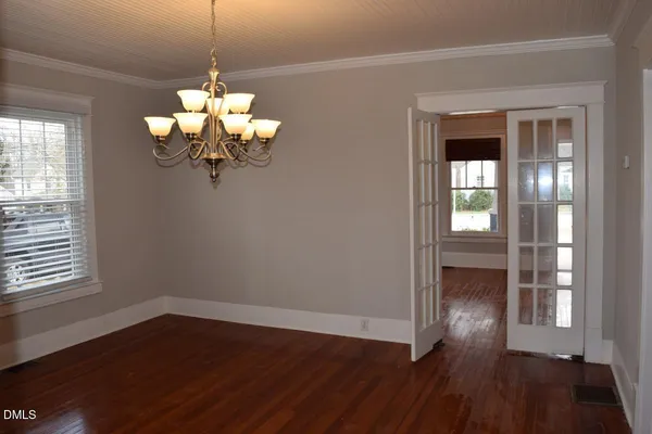 a view of a room with wooden floor chandelier and entryway