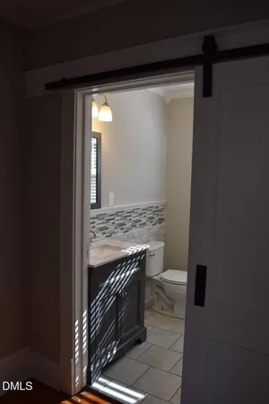 a bathroom with a granite countertop sink and a toilet