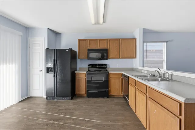 a kitchen with stainless steel appliances granite countertop a refrigerator stove and sink