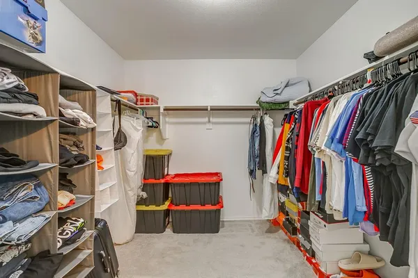 a view of walk in closet with clothes and shoes