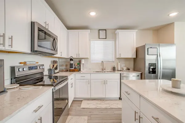 a kitchen with stainless steel appliances granite countertop a sink stove and refrigerator