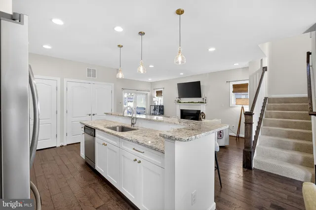 a kitchen with stainless steel appliances granite countertop a sink a refrigerator and a stove