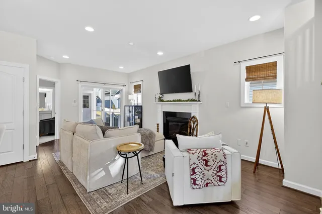 a living room with furniture a fireplace and wooden floor