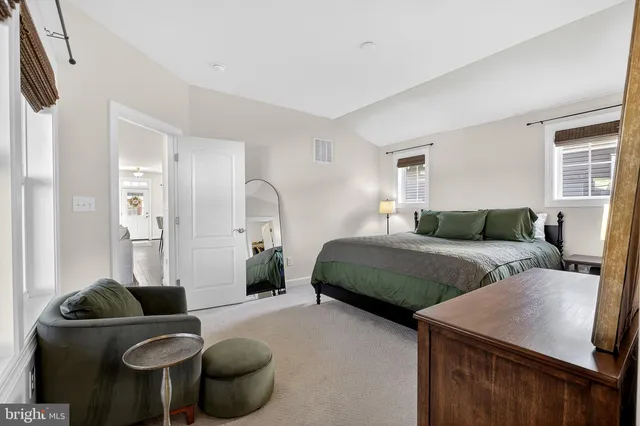 a bedroom with a bed and dresser with mirror