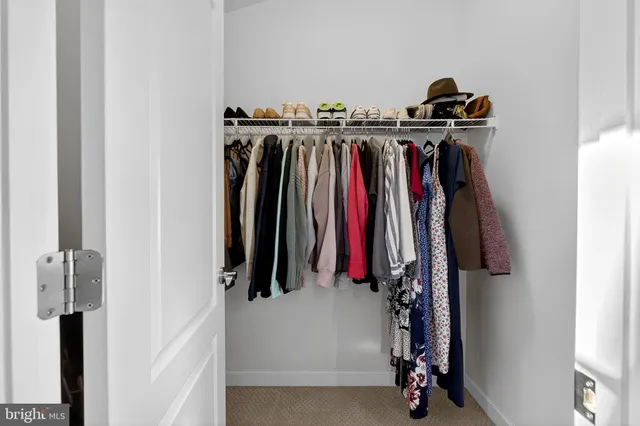 a view of walk in closet with clothes and shoes