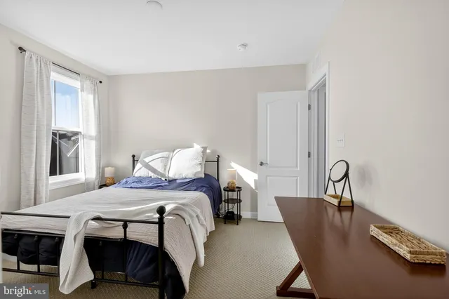 a bedroom with a bed chair and a window