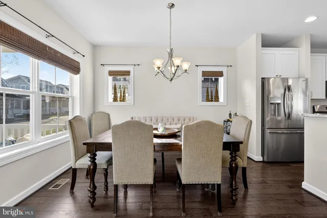 a dining room with furniture a chandelier and wooden floor