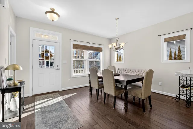 a dining room with furniture a chandelier and wooden floor