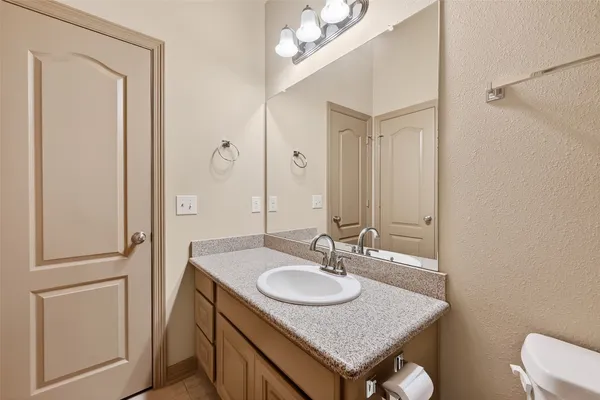 a bathroom with a granite countertop sink a toilet and a mirror