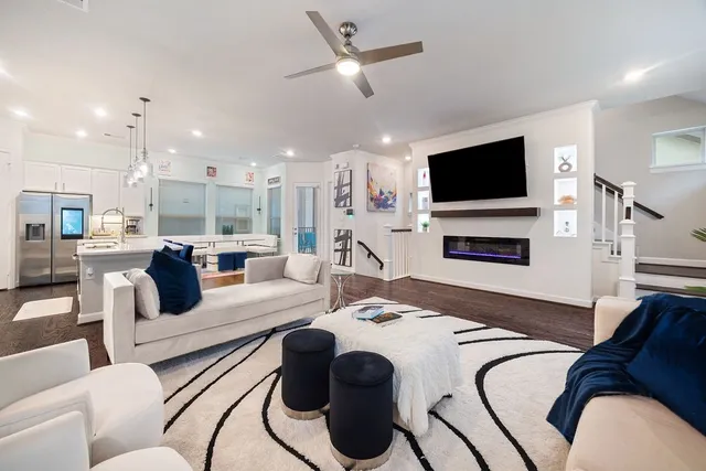 a living room with fireplace furniture flat screen tv and wooden floor