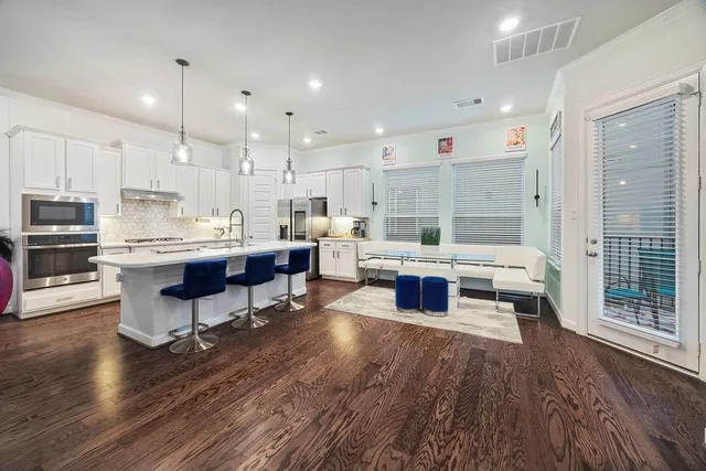 a living room with lots of furniture and kitchen view