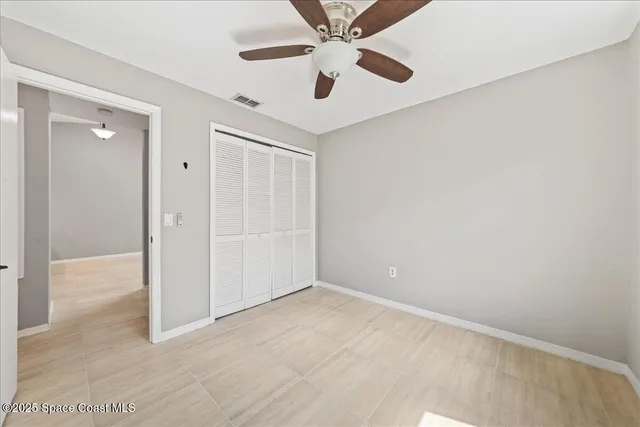 an empty room with fan and entrance