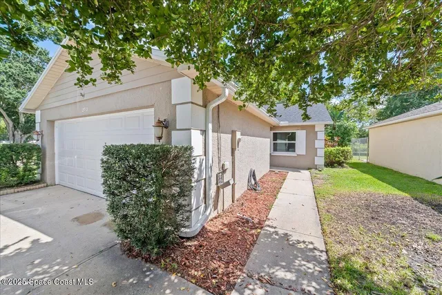 a front view of a house with a yard and potted plants