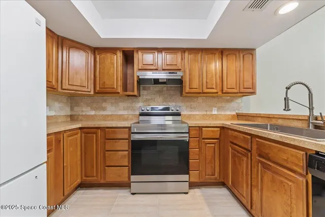 a kitchen with granite countertop cabinets stainless steel appliances and a sink