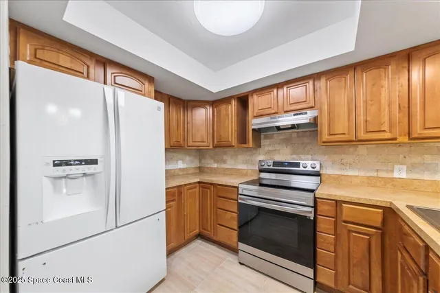 a kitchen with stainless steel appliances granite countertop a refrigerator sink and stove