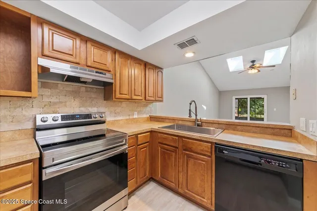 a kitchen with stainless steel appliances granite countertop a sink stove and cabinets