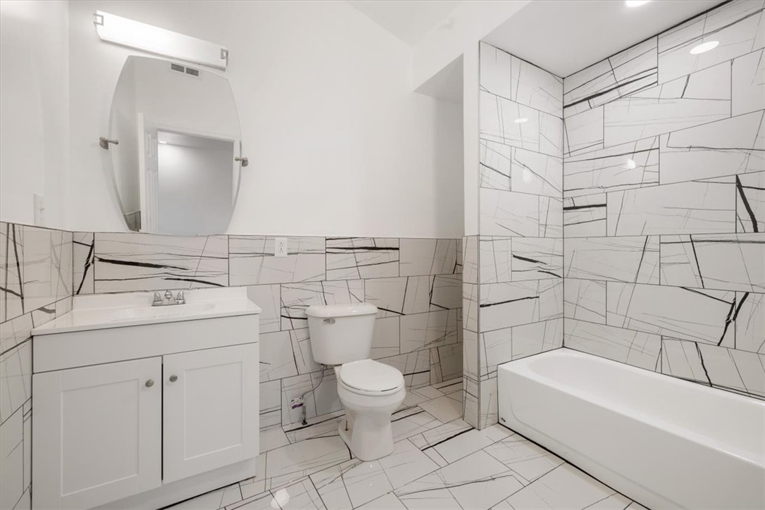 629 Little Meadow Drive Riverside, OH 45404 - Photo 29 of 48 This newly renovated bathroom features sleek tiled walls and a modern vanity, offering a pristine and contemporary aesthetic.