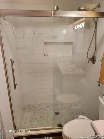 a bathroom with a toilet and a shower