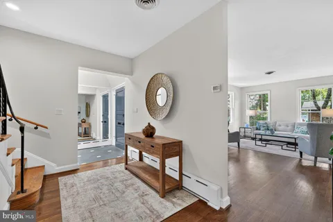 a living room with furniture and a large mirror next to a window