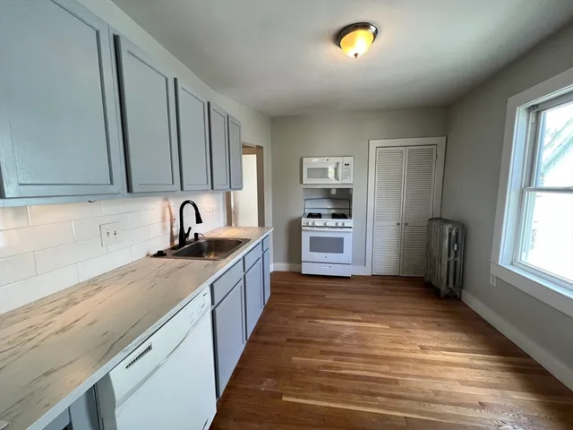 a kitchen with granite countertop a sink stainless steel appliances and cabinets