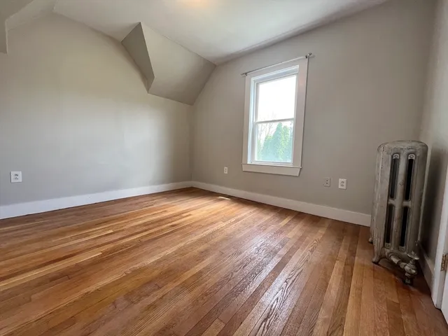 a view of a room with wooden floor and a window
