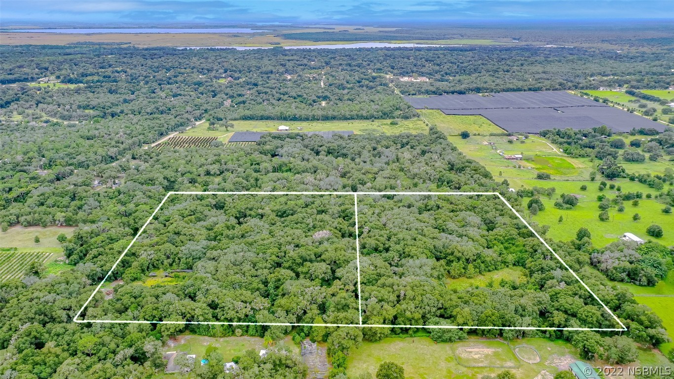0 Reynolds Road De Leon Springs, FL 32130 - Photo 1 of 12 a view of a city with lush green forest