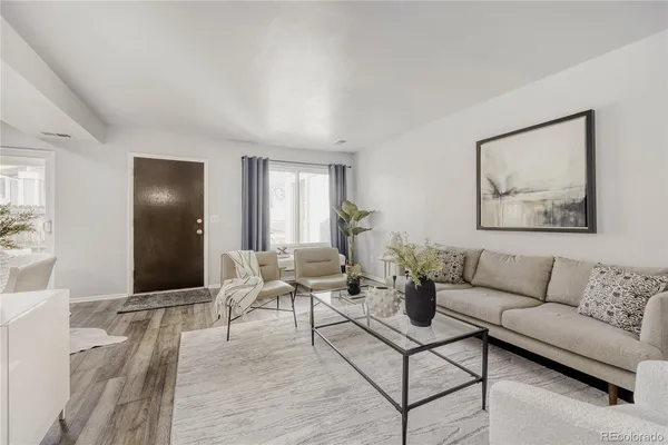 a living room with furniture and wooden floor