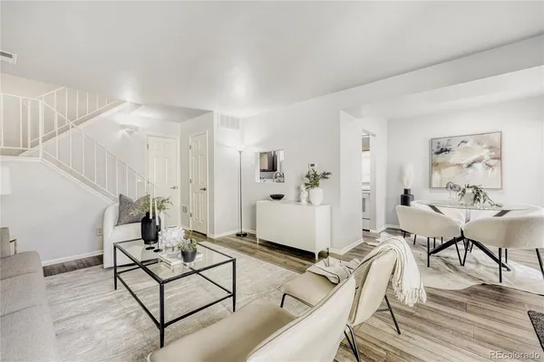 a living room with furniture and wooden floor