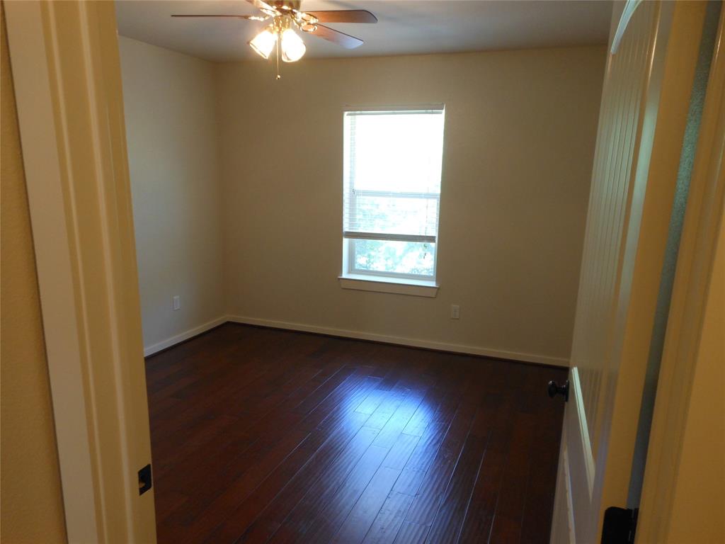 206 Highway 342, Unit K Red Oak, TX 75154 - Photo 13 of 14 a view of an empty room with wooden floor and a window